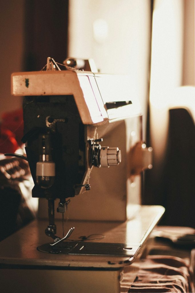 an older type of sewing machine standing in a room in the light of the setting sun
